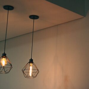 Home Stylish geometric pendant light fixtures casting warm light in a minimalistic indoor setting.